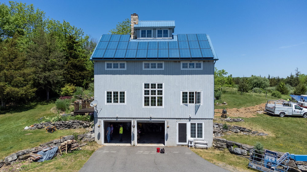 Roof panels with blue metal SolarSkin™ installed by Geoscape Solar Blue roof solar panels blend in with the unique blue roof of home to hide solar panels