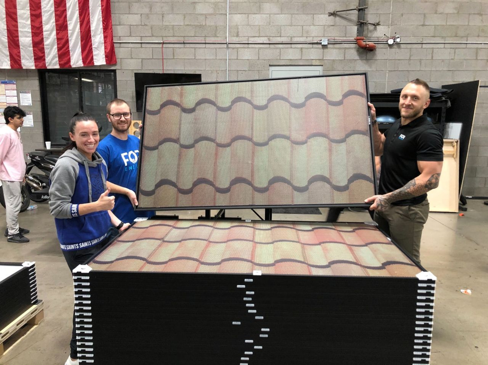 The FOR Energy crew shows off SolarSkin outfitted REC Alpha black panels at the Titan Energy warehouse in AZ