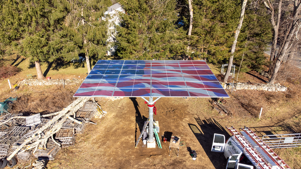 Dual axis tracker installed with a red controller box on the mounting pole below the solar array on top