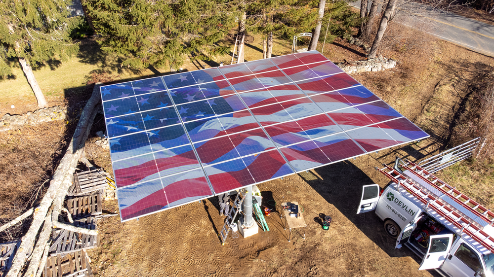 Large 24-panel solar array with waving American flag design on top, positioned parallel to ground